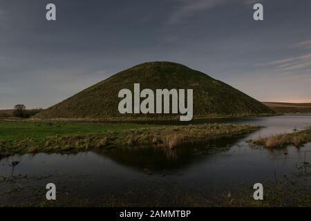 Der riesige neolithische Kreidehügel von Silbury Hill, Avebury, Wiltshire, Großbritannien, hier bei Mondschein zu sehen. Er ist 40 m hoch und wurde um 2300 v. Chr. erbaut Stockfoto