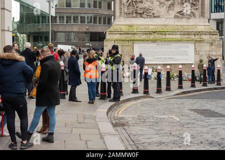 London, Großbritannien. Januar 2020. Menschen, die auf einen Gottesdienst, ein Gedenken und die Tributebeseitigung am Monument für die Anschläge der London Bridge vom 29. November 2019 warten. Die Blumen, die am Denkmal gelegt werden, werden kompostiert und stehen den Familien der Opfer zur Verfügung.