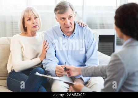 Senioren-Paar spricht zu Hause mit Finanzberater Stockfoto