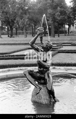 Bronzeskulpturen von Adriaen de Vries im Schlosspark von Drottningholm auf der Insel Lovön, Neptun läst in einem Muschelhorn, 1969. Bronze-Scultpuren von Adriaen de Vries im Garten des Schlosses Drottningholm auf der Insel Lovön, Neptun, das in eine Konchmuschel bläst, 1969. Stockfoto