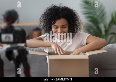 Afrikanerin nimmt den Moment der Kamera fest, als sie bestellte Waren entpackt hat Stockfoto