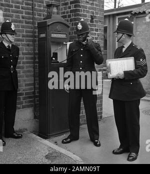 Er wird neun Tage lang als erster schwarzer Polizist in London, PC Norwell Gumbs, 21, am Metropolitan Police Training College in Hendon, London ausgebildet, da ihn Station Sgt John Aldridge anweist, ein Polizeitelefon zu benutzen. Stockfoto