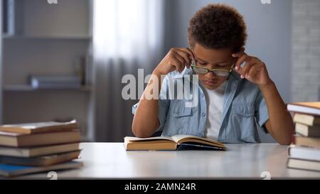 Geballte Schüler in Brillen, die Literatur in der Bibliothek lesen, nerd Junge Stockfoto