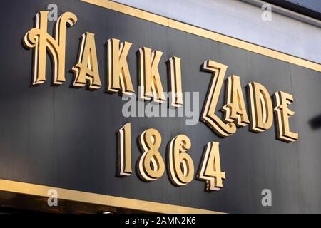 HAKKI Zade wurde 1864 als Konditor gegründet. HAKKI Zade Schild in der Nähe fotografiert. Goldfarbe auf schwarzer Oberfläche. Stockfoto