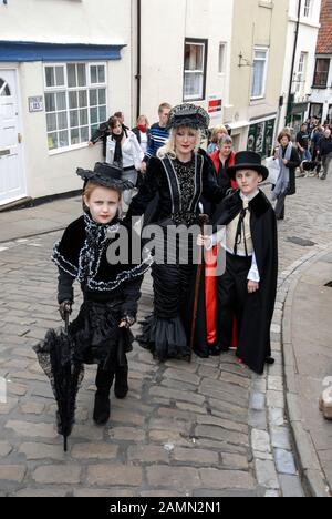 Goth Convention Weekend in Whitby, North Yorkshire in Großbritannien EINE Familie, die in Goth-Kleidung Gekleidet Ist Hunderte von schwarz gekleideten Goten steigen auf die historische Stockfoto