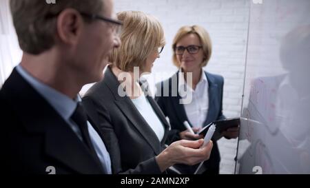 Lächelnde glückliche Geschäftsfrau, die mit Partnerplänen spricht, genehmigt Deal Stockfoto