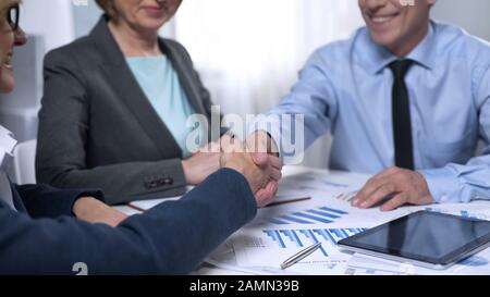 Treffen von männlichen Anlegern mit Vertretern von Damenunternehmen, Besprechung des Vertrags Stockfoto