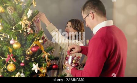 Vater und Tochter schmücken Weihnachtsbaum, zusammen im Urlaub, festliche Stimmung Stockfoto