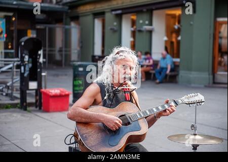 Oslo, Norway-1. August 2013: Ein Straßenmusiker tritt auf der Hauptstraße von Karl Johans Tor auf. Diese Straße ist eine der belebtesten in der Stadt, voller Stockfoto