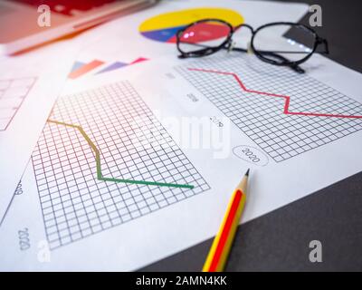 Geschäftszielkonzept. Business-Zubehör, Diagramme, Bleistift, Laptop und Brille auf dem Tisch. Stockfoto