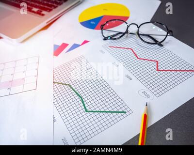 Geschäftszielkonzept. Business-Zubehör, Diagramme, Bleistift, Laptop und Brille auf dem Tisch. Stockfoto