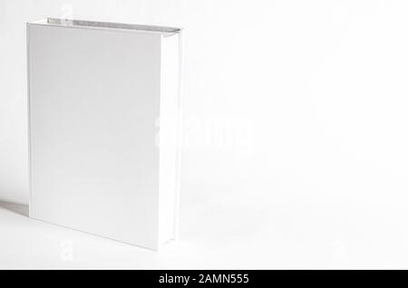 Verspottung eines geschlossenen leeren, quadratischen Buchs auf weißem, strukturiertem Papierhintergrund Stockfoto