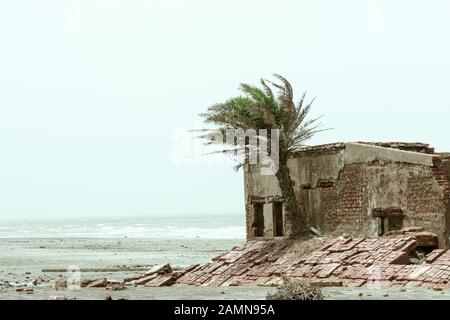 Eine alte Ruine verlassene Haus am Strand. Beschädigte zerbrochene zerstörte Gebäude aus befestigter Ziegelmauer außen. Architektur Natur Landschaft Backg Stockfoto