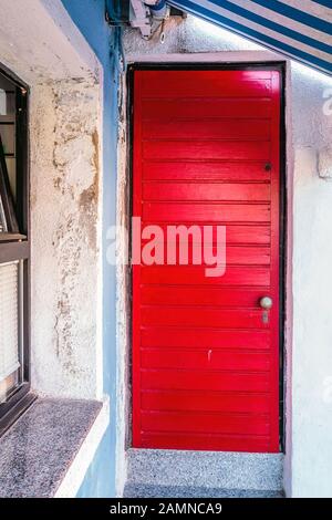 Malerische hellrote Haustür auf der berühmten Insel Burano, Venedig, Italien Stockfoto