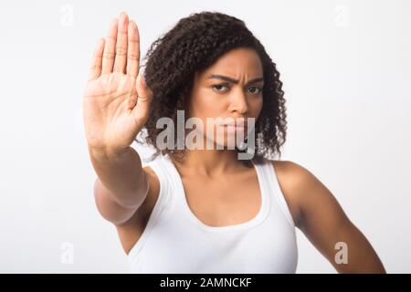 Afro Mädchen mit Stoppschild auf weißem Hintergrund Stockfoto