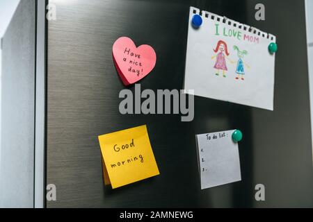 Familienanmerkung und Notizen mit Wünschen, die am Kühlschrank hängen Stockfoto