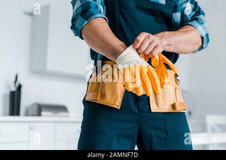 3/4-Ansicht des Handarbeiters in Uniform mit Gummihandschuh Stockfoto