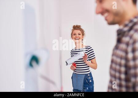 Porträt einer lächelnden Frau, die Wände in ihrer neuen Wohnung malte Stockfoto