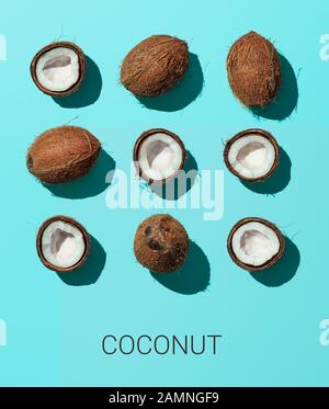 Helles Muster mit Kokosnuss. Tropischer abstrakter Hintergrund. Kokosnuss auf blauem Hintergrund. Draufsicht oder flache Lage. Hartes Licht Stockfoto