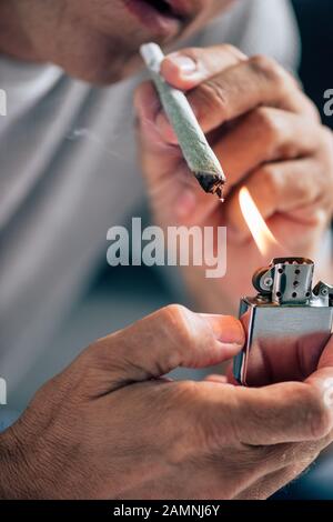 Die beschnittene Ansicht des Mannes, der mit medizinischem Cannabis stumpf aufleuchtet Stockfoto