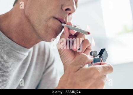 Die beschnittene Ansicht des Mannes, der mit medizinischem Cannabis stumpf aufleuchtet Stockfoto