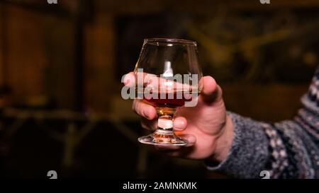 Nahaufnahme von Personen, die Glas mit Whisky oder Bourbon in der Hand halten. Konzept des Nachtlebens Stockfoto