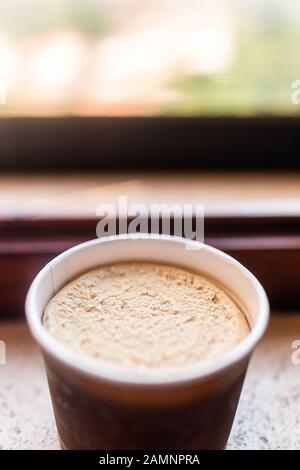 Eine Tasse Eiscreme Gelatopapier aus brauner Kaffeeschokolade auf dem Fenstertisch traditionelle Dessertspeisen in Italien Makro Closeup mit Textur Stockfoto