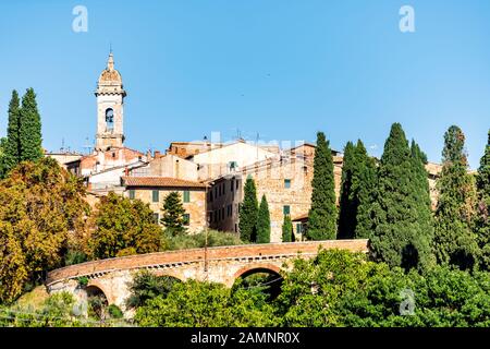 San Quirico D'Orcia, italienische Dorfstadt in der Toskana während des sonnigen Sommertags und berühmter Kirchturm Blick auf Stadtbild und Mauer Stockfoto