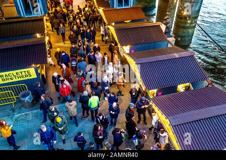 Leute, die Stände im festlichen Southbank Centre Winter Market, London, Großbritannien, betrachten Stockfoto