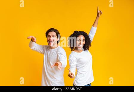 Sorgloser Kerl und Mädchen, die zurück nach hinten tanzen und gemeinsam Spaß haben Stockfoto