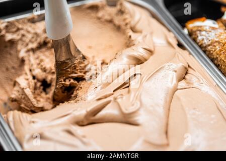 Makro-Nahaufnahme von Schokoladenkaffee Gelato-Eis mit wirbelnden Schaufeln im Café-Shop im berühmten Florenz Italien Firenze Centrale Mercato Stockfoto