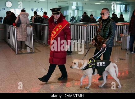 (200114) -- ZHENGZHOU, 14. Januar 2020 (Xinhua) -- der Führerhund Xiaoqi führt seinen Handler dazu, Tickets mit Hilfe eines Eisenbahnpersonals im Bahnhof Zhengzhoudong in Zhengzhou, der zentralchinesischen Provinz Henan, am 14. Januar 2020 zu kaufen. Der sehbehinderte Passagier namens Jin würde am Dienstag im Bahnhof Zhengzhoudong mit seinem Führerhund Xiaoqi einen Einschusszug nehmen. Er telefoniert mit dem Bahnhof um Hilfe. Die Mitarbeiter des Bahnhofs erarbeiteten sofort einen Plan, um sicherzustellen, dass der Fahrgast und sein Blindenhund eine bequeme und sichere Fahrt ohne Hindernisse haben. (Xinhua/Li Stockfoto