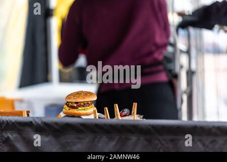 Burger Cheeseburger Straßenküche im Straßenrestaurant mit Küchenchef in verschwommener Hintergrundküche Stockfoto