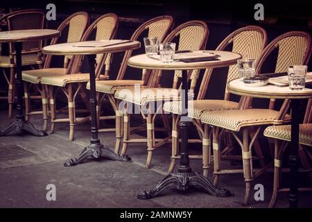 Leere Retro-Tische und -Stühle auf einer Café-Terrasse im Freien in Paris, Frankreich Stockfoto