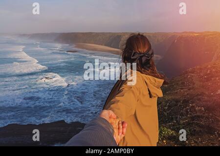 Junge Frau mit männlichen Hand close-up in der Nähe des Ozeans. Stockfoto