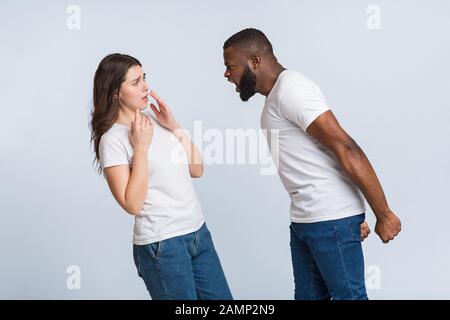 Wütender Afro-Kerl, der emotional seine verängstigte Freundin anruft und ihr die Schuld gibt Stockfoto