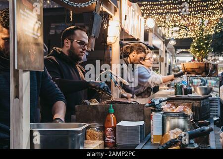 London, Großbritannien - 29. Dezember 2019: Verkäufer an den Verkaufsständen auf Dem Spitalfields Market, einer der besten viktorianischen Markthallen in London mit Verkaufsständen Stockfoto