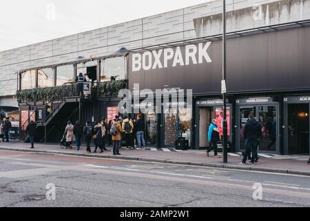 London, Großbritannien - 29. Dezember 2019: Menschen, die an den Geschäften von BOXPARK Shoreditch, London, vorbeilaufen, ein Container-Pop-up-Einkaufszentrum für unabhängige und Modegeschäfte Stockfoto