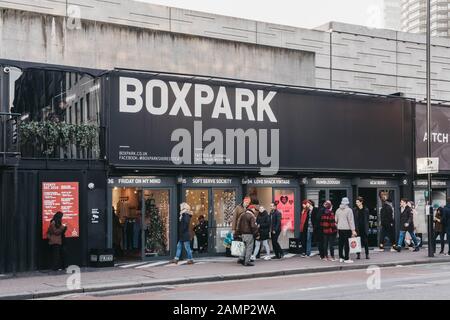 London, Großbritannien - 29. Dezember 2019: Menschen, die an den Geschäften von BOXPARK Shoreditch, London, vorbeilaufen, ein Container-Pop-up-Einkaufszentrum für unabhängige und Modegeschäfte Stockfoto