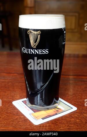 Ein Pint Guinness in einem hohen dünnen Glas Stockfoto