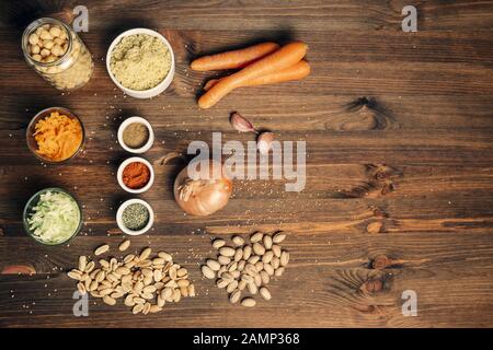 Stillleben mit Burger Zutaten für vegane Proteinquelle auf Holzhintergrund, Draufsicht, vegetarisches Essen und gesundes Lifestyle-Konzept Stockfoto