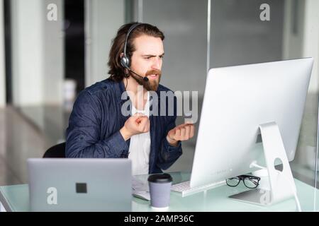 Call Center Betreiber an seinem Schreibtisch arbeiten Stockfoto