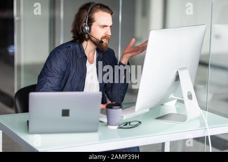 Call Center Betreiber an seinem Schreibtisch arbeiten Stockfoto