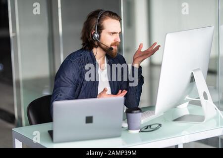 Call Center Betreiber an seinem Schreibtisch arbeiten Stockfoto