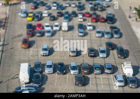 Großer Parkplatz mit vielen verschiedenen Autos, von oben gesehen, mit Neigungsschalteffekt Stockfoto