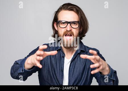 Wütender Mann, der eine Brille trägt, die auf grauem Studiohintergrund isoliert ist, ärgert sich über laute Geräusche. Stockfoto