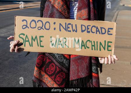 Protest gegen Krieg 2020 - Neue Decade-Same War Machine - Frau in Schal hält hausgemachte Zeichen Stockfoto