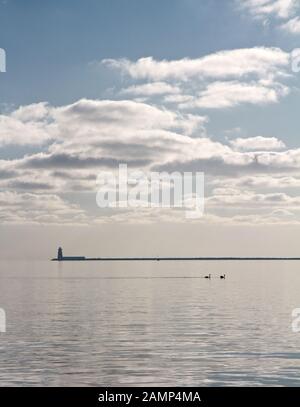 Poolbeg Lighthouse am Ende der Great South Wall, abgebildet von Dollymount Strand in Dublin, Irland. Stockfoto