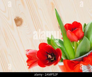 Blumenstrauß aus Tulpen in einem eisernen Eimer mit rotem Bogen Stockfoto