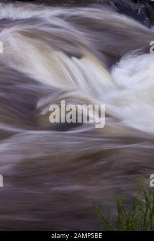 Abstrakte, langsame Aufnahme von schnell fließendem weißem Wasser. Stockfoto